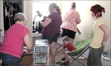 Shane Damico|Staff Criminology freshman Christina Westhoek (right) stands aside as her family helps her move into a Phase VIII apartment.