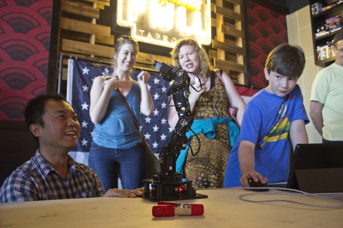 Connie Cheng | Photo Editor
Doctoral candidate Jingfu Jin demonstrates how a mechanized mini-arm works to moviegoers on June 27. Students and faculty from the School of Engineering and Computer Science hosted the event at Alamo Drafthouse.