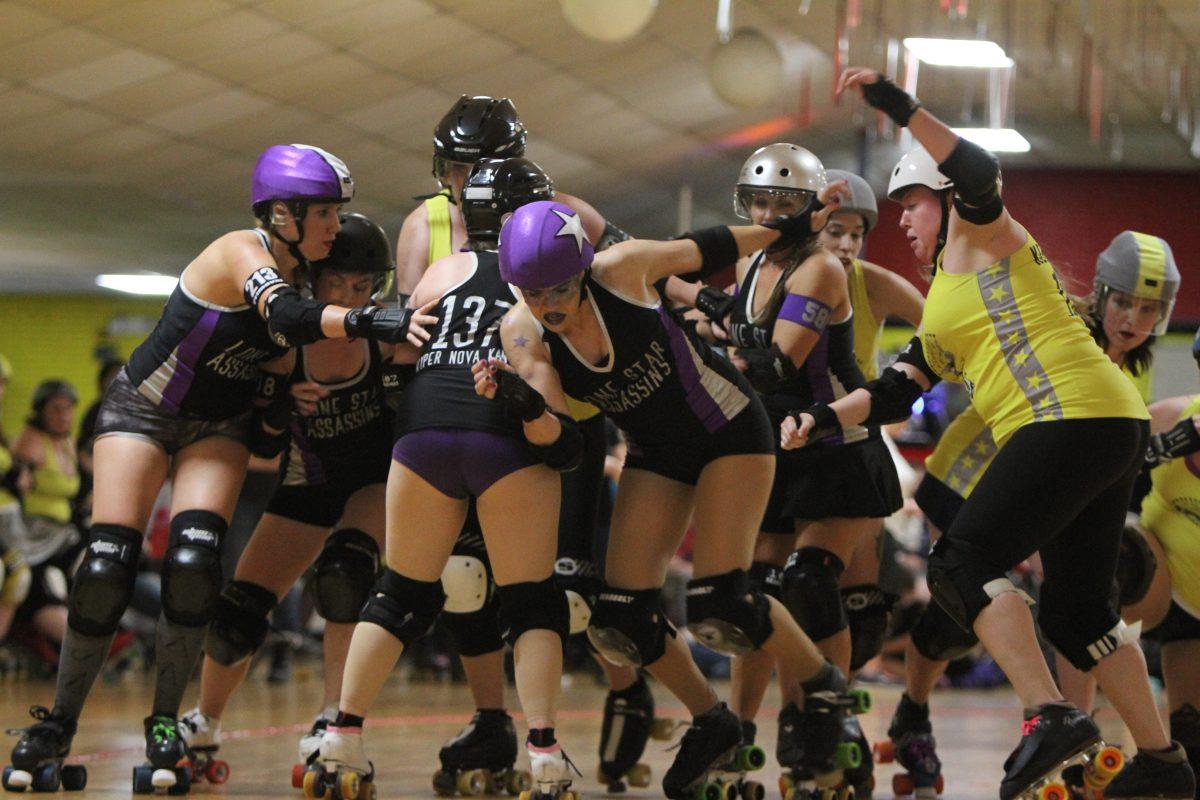 Lone Star Assassins and Deadly Kennedys, both of which have UTD alumni on their rosters, battle during a bout on Feb. 11 at Thunderbird Roller Rink in Plano. The Assassination City Roller Derby is made up of four home teams and a travelling all-star team. The regular season, which runs from February through July, consists of a double round-robin that sees the four home teams competing in six monthly doubleheaders leading up to their seeded championship tournament held in August. Photo by Saher Aqeel | Photo Editor.