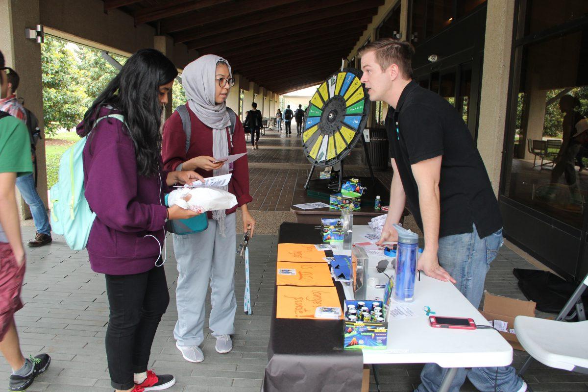 History junior Wania Uddin (left) and biology sophomore Hira Ali speak with Christopher Franson, the president of Ethical Hackers, at the organization's first fundraise. Photo by Ruth Varghese | Mercury Staff.