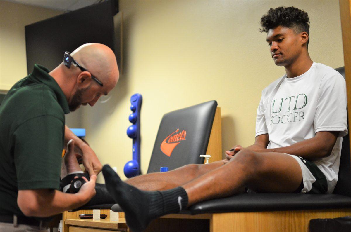 Head athletic trainer Josh Dreher helps wrap junior midfielder Hunter Williams’ foot on the morning of Sept. 13. Dreher works primarily with men’s soccer. Photo by Vyasraj Vajramani | Mercury Staff.