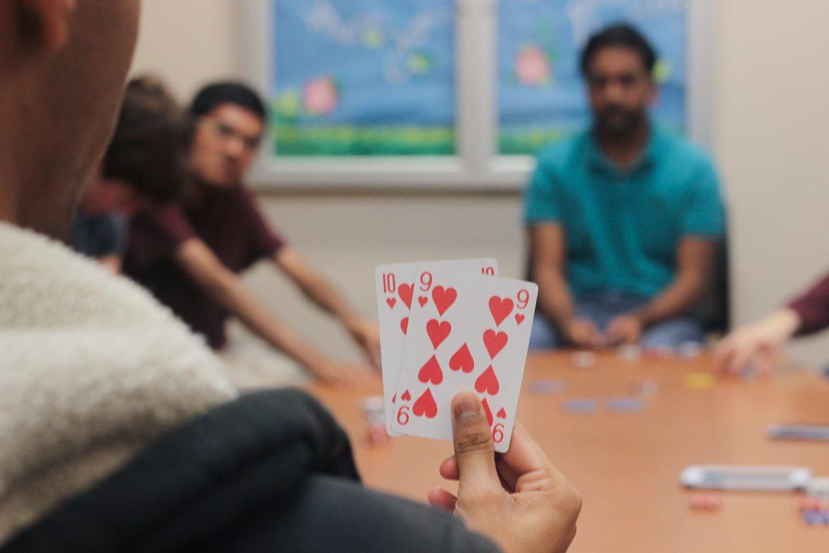 Mechanical engineering freshman Neil Kale looks at his cards as the round begins during a poker game on Oct. 12. Photo by Srikar Sudarsan Baskara | Mercury Staff.