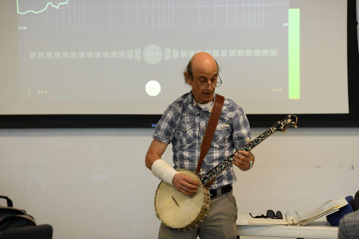 Joseph Izen plays his banjo in his honors physics class. Izen began playing during his graduate years in 1980. Photo by Aasav Sureja | Mercury Staff.