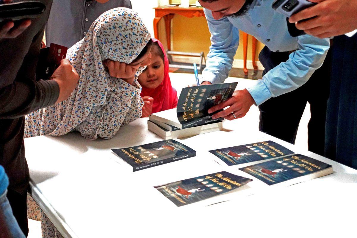 Former Comet Badees Nouiouat signs copies of his book for young fans. | Photo courtesy of Badees Nouiouat