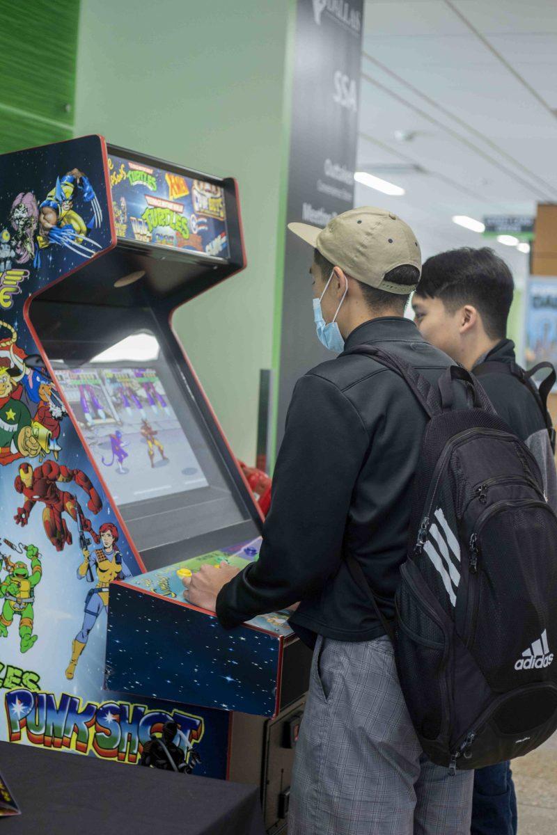 Two Comets play an old school Teenage Mutant Ninja
Turtles arcade fighting game at Comet Con. Photo by Fatimah Azeem | Opinion Editor