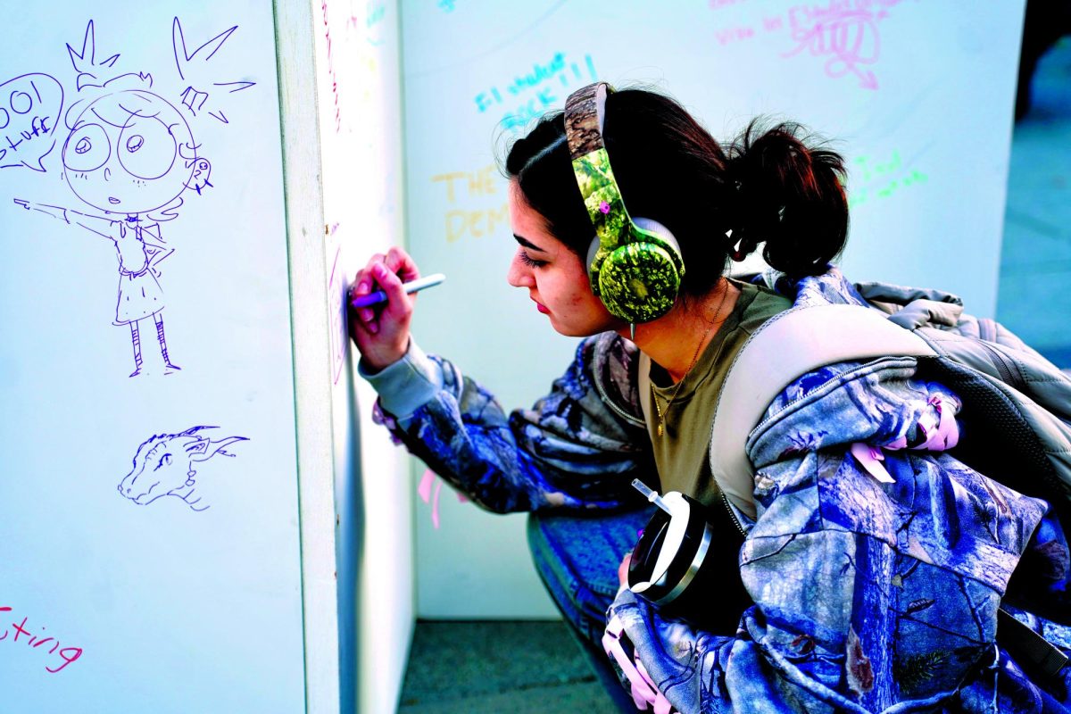 Students share thoughts, doodles and messages on The Mercury’s free speech board at its relaunch event. 