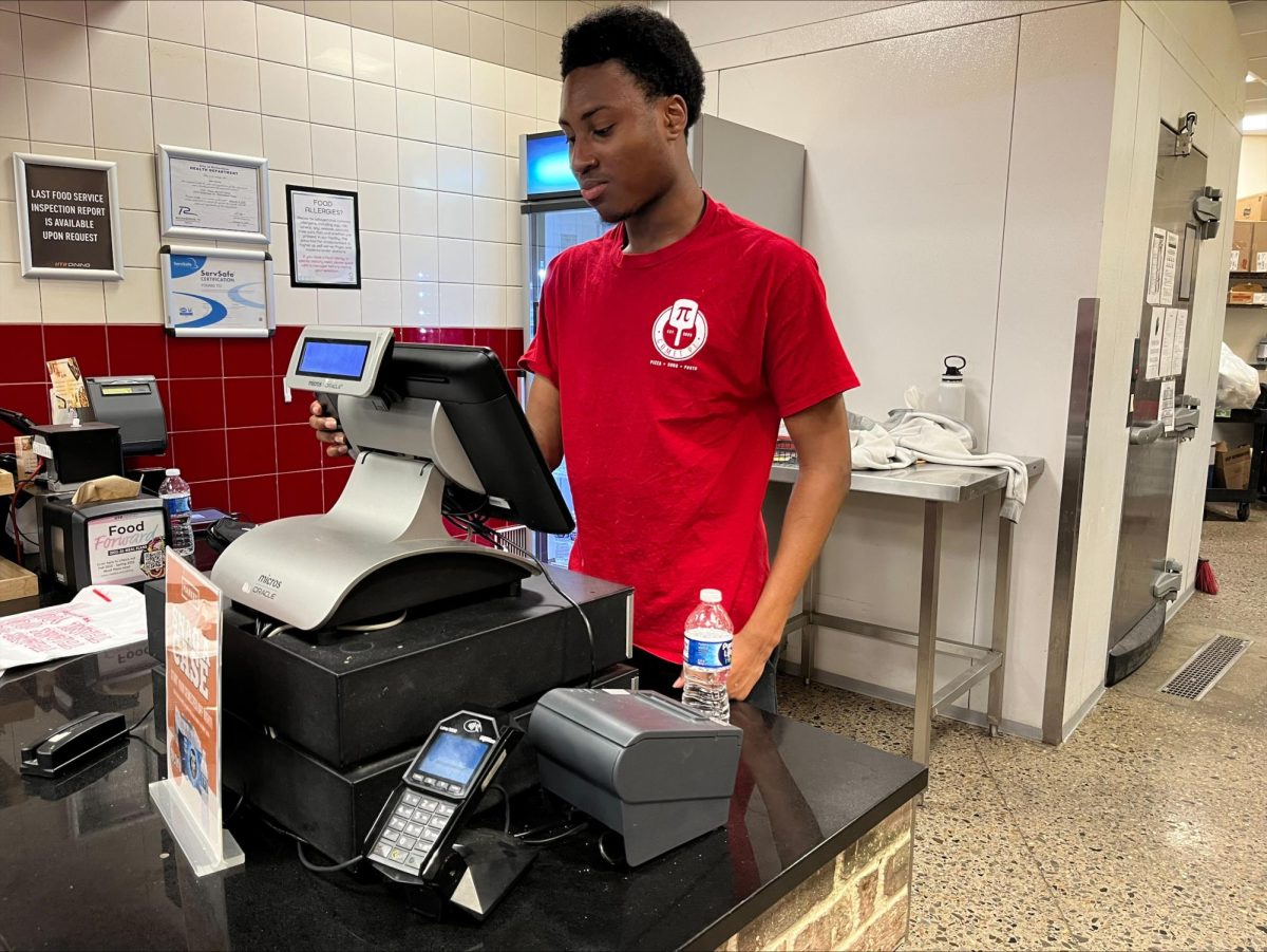 Freshman Mohammed Kouyate operates the cash register for the Comet Pi restaurant. 